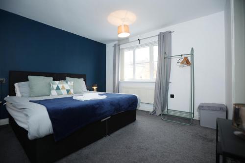 a blue bedroom with a bed and a window at Milestone House By N And N Stays, Contractor Friendly, 6 Bed house, Sleeps 10, Private Parking, WIFI in Cardiff