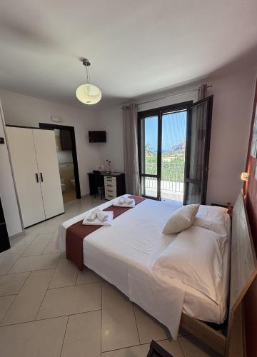a bedroom with a large bed and a large window at B&B La Chiocciola in Castelluzzo