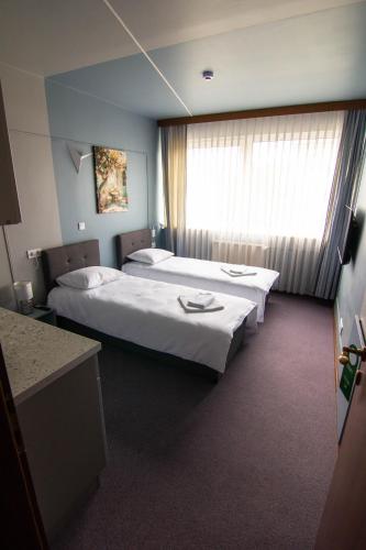 a hotel room with two beds and a window at Hotel Vento in Ventspils