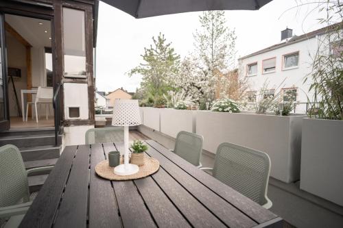 a wooden table with a lamp on a balcony at Juno Living - Witten Apartmenthaus in Witten