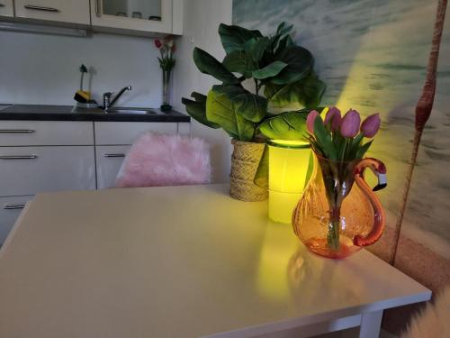 a vase with flowers on a table in a kitchen at FlamingoSuite 6 min zum See in Herrsching am Ammersee