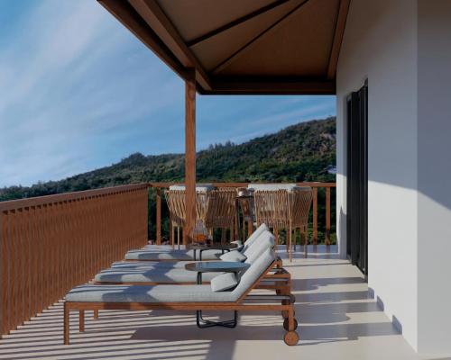 a row of lounge chairs on a balcony at Coral Strand Smart Choice in Beau Vallon