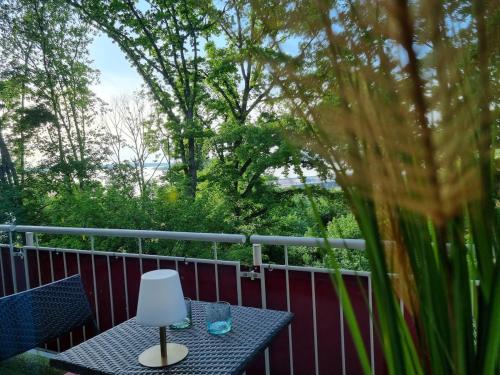 a table with a lamp on a balcony at FlamingoSuite 6 min zum See in Herrsching am Ammersee