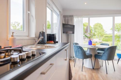 a kitchen with a counter and a table and chairs at Chalet Artistique in Oldeberkoop