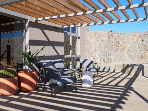 a patio with chairs and a wooden pergola at Goats Window Luxury Safari Lodge in Bonnievale