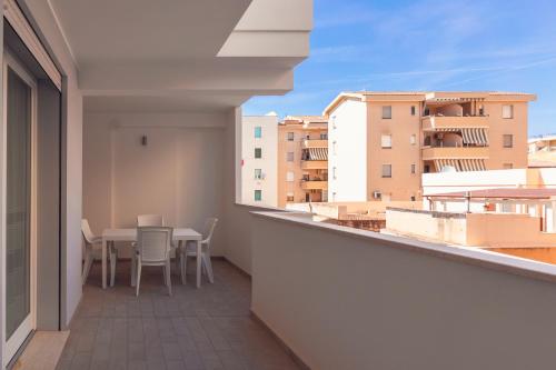 a balcony with a table and chairs and buildings at Alessia in wonderland in Alghero