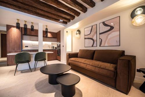 un salon avec un canapé et une table dans l'établissement Charming Flat in Magnificient Place des Vosges, à Paris