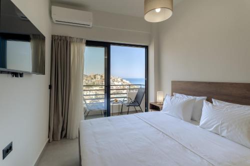 a bedroom with a bed with a view of the ocean at Trinity Suites "by Checkin" in Balíon