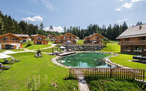 a resort with a pool in the middle of a yard at Lerchpeuntgut Almchalets in Tamsweg