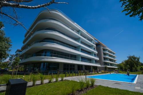 a building with a swimming pool in front of it at MyFlat Wave Botanic Apartment in Siófok