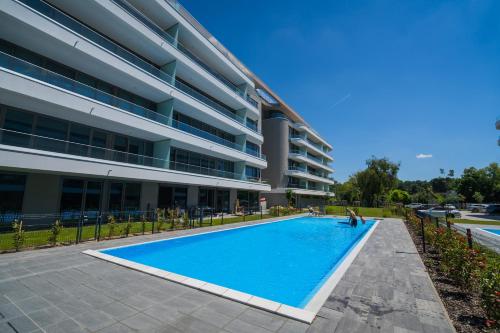 a large swimming pool in front of a building at MyFlat Wave Botanic Apartment in Siófok