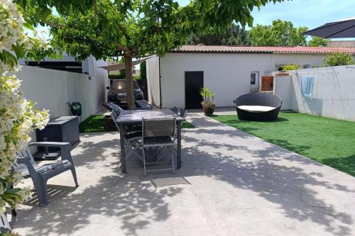 un patio avec une table et des chaises dans une cour dans l'établissement Maison moderne de 100m2 avec jardin, à Vias