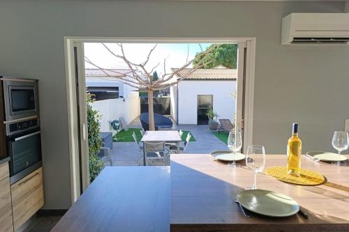 une cuisine avec une table avec des verres à vin dessus dans l'établissement Maison moderne de 100m2 avec jardin, à Vias