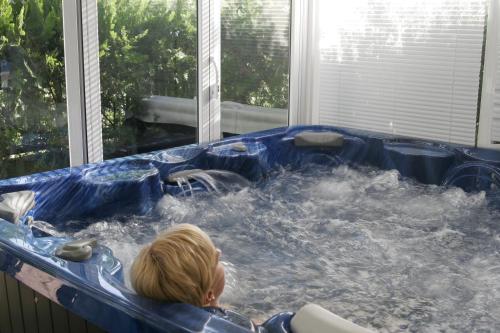 a child is sitting in a jacuzzi tub at Suite Hotel S'Argamassa Palace in Santa Eularia des Riu