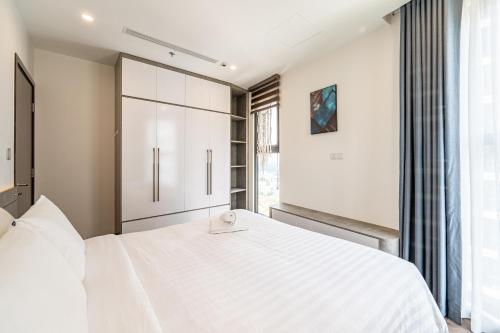 a bedroom with a large white bed and a window at Studio-GH5 - Vinhomes Grand Park - Thu Duc City in Long Bình