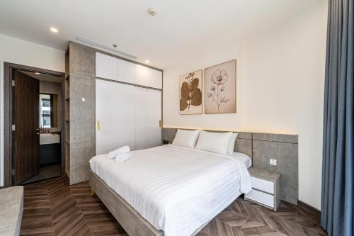 a bedroom with a large white bed and a bathroom at Studio-GH5 - Vinhomes Grand Park - Thu Duc City in Long Bình