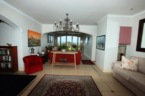 a living room with a red couch and a table at On The Cliff Guest House in Hermanus