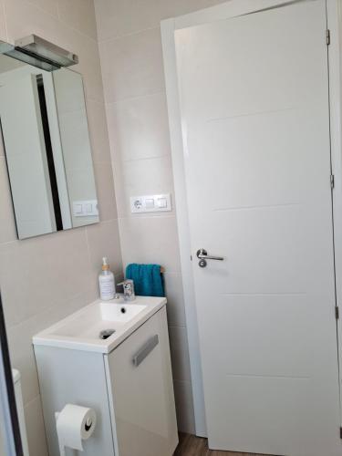 un bagno bianco con lavandino e specchio di Atico con vistas a la Ría a A Pobra do Caramiñal