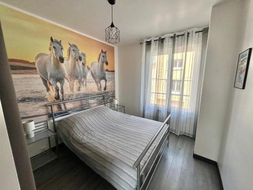 - une chambre avec un lit et une peinture de chevaux dans l'établissement Appartement à deux pas de la plage - 1 chambre, à Berck-sur-Mer