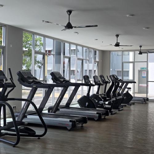 a row of treadmills in a gym with windows at Alanis Studio With Neflix in Sepang