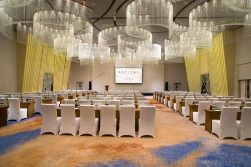a room with rows of chairs and a projection screen at Sofitel Kunming in Kunming
