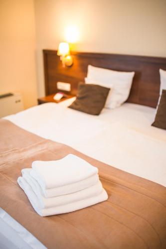 a pile of towels sitting on a bed at Dosłońce Resort Wellness & Farm in Racławice