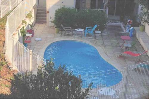 - une piscine dans une cour avec des chaises et une table dans l'établissement soleil d azur, à La Ciotat