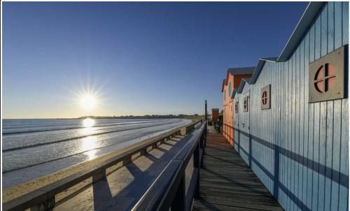 a building on a pier next to the beach at Cocon cosy entre terre & mer in Le Fenouiller