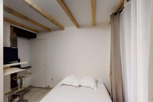 une chambre avec un lit blanc et une fenêtre dans l'établissement Le Veyrier - Small studio for 2 people in the heart of the old town, à Annecy