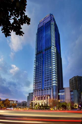 a tall building with blue windows in a city at Sofitel Kunming in Kunming