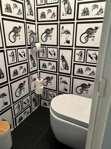a bathroom with a toilet and a wall with cats on it at Onder de Paddn in Wapenveld