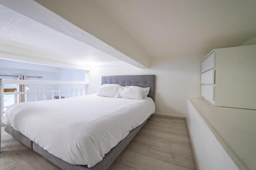 - une chambre blanche avec un grand lit et des draps blancs dans l'établissement Le Semnoz - studio with mezzanine in the heart of the old town, à Annecy