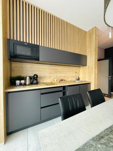 a kitchen with a counter and a table and chairs at Jasna SportHotel & SPA in Gliwice