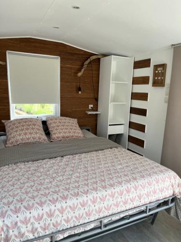 une chambre avec un lit et une grande fenêtre dans l'établissement Studio chalet, à La Celle-sous-Gouzon