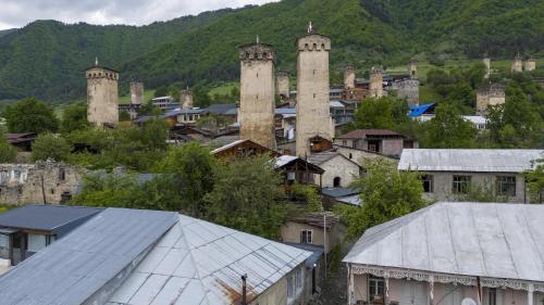 a town with towers on a hill with houses at Apartment Gira In Mestia in Mestia
