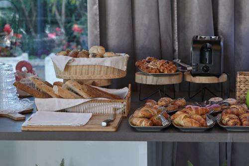 a table with several baskets of bread and pastries at Boutique Hotel Life in Rogoznica
