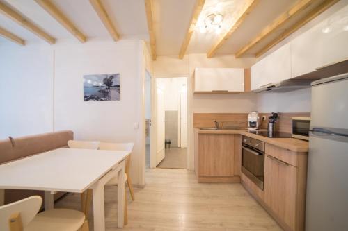 une cuisine avec une table et un comptoir blanc dans l'établissement Le Parmelan - apartment for 2 people in the heart of the old town, à Annecy