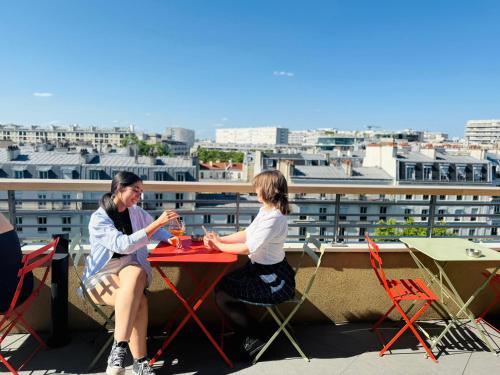 two women sitting at a table on a roof at The People - Paris Bercy in Paris