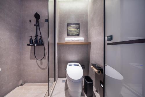a bathroom with a toilet and a glass shower door at Atour Hotel Chengdu Sichuan University North Kehua Road in Chengdu