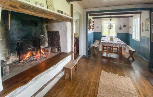 a living room with a fireplace and a dining room table at Awesome Home In Buskahult With Sauna 