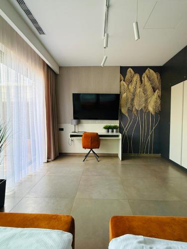 a room with a tv and a desk and a chair at Jasna SportHotel & SPA in Gliwice