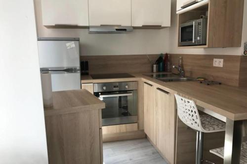 une cuisine avec des armoires en bois et un réfrigérateur blanc dans l'établissement La Tournette - Apartment for 2-4 people in the heart of the old town, à Annecy