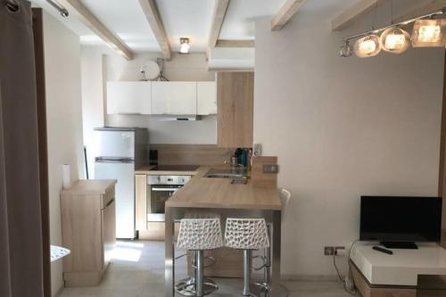 une cuisine avec un évier et un comptoir avec des tabourets dans l'établissement La Tournette - Apartment for 2-4 people in the heart of the old town, à Annecy