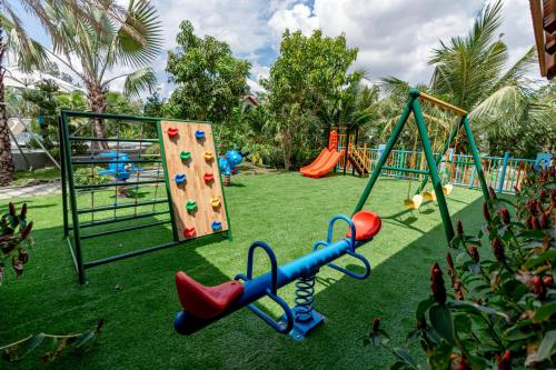 a playground with slides and climbing equipment in a park at Le Palmier Long An Boutique Resort - Free Outdoor Cinema in Ấp Kế Mỹ