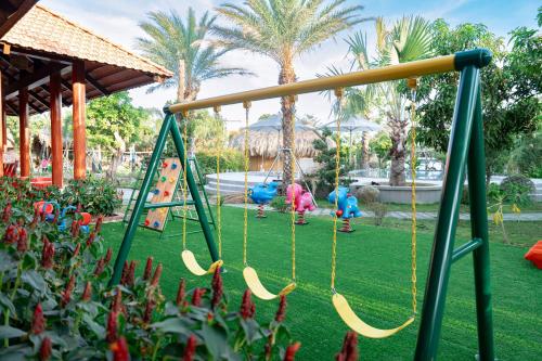 a swing set in a park with children playing at Le Palmier Long An Boutique Resort - Free Outdoor Cinema in Ấp Kế Mỹ
