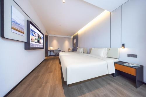 a bedroom with a large white bed and a tv at Atour Hotel Chengdu Sichuan University North Kehua Road in Chengdu