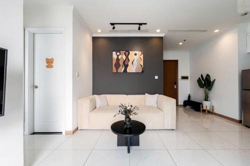 a living room with a white couch and a table at Landmark Plus Vinhomes CityView Suite in Ho Chi Minh City