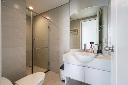 a bathroom with a sink and a toilet and a shower at Landmark Plus Vinhomes CityView Suite in Ho Chi Minh City