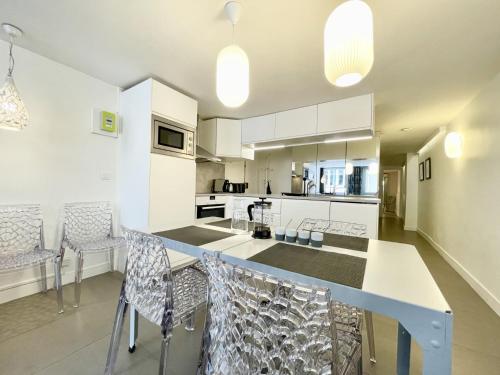 une cuisine avec des placards blancs et un comptoir avec des chaises dans l'établissement 202419 - Elegant apartment for 6 people in the Montorgueil area, à Paris