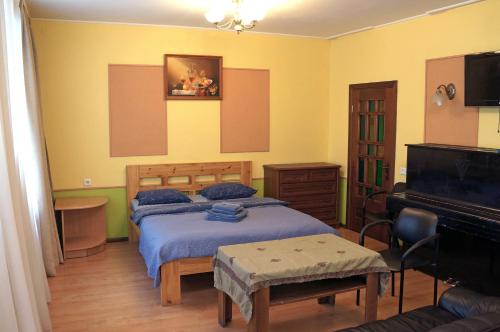 a bedroom with two beds and a piano at Apartament Erfolg 12 in Daugavpils